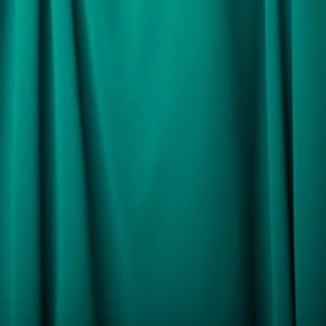 Turquoise curtain with gentle folds and shadows.