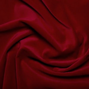 Rich red velvet fabric texture, soft and luxurious.
