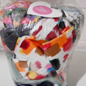 Bag of colourful fabric scraps wrapped in plastic.