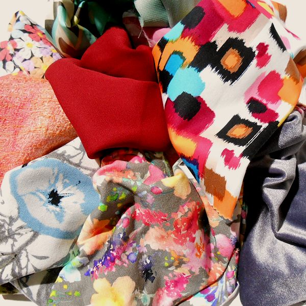 Colourful pile of various fabric patterns.