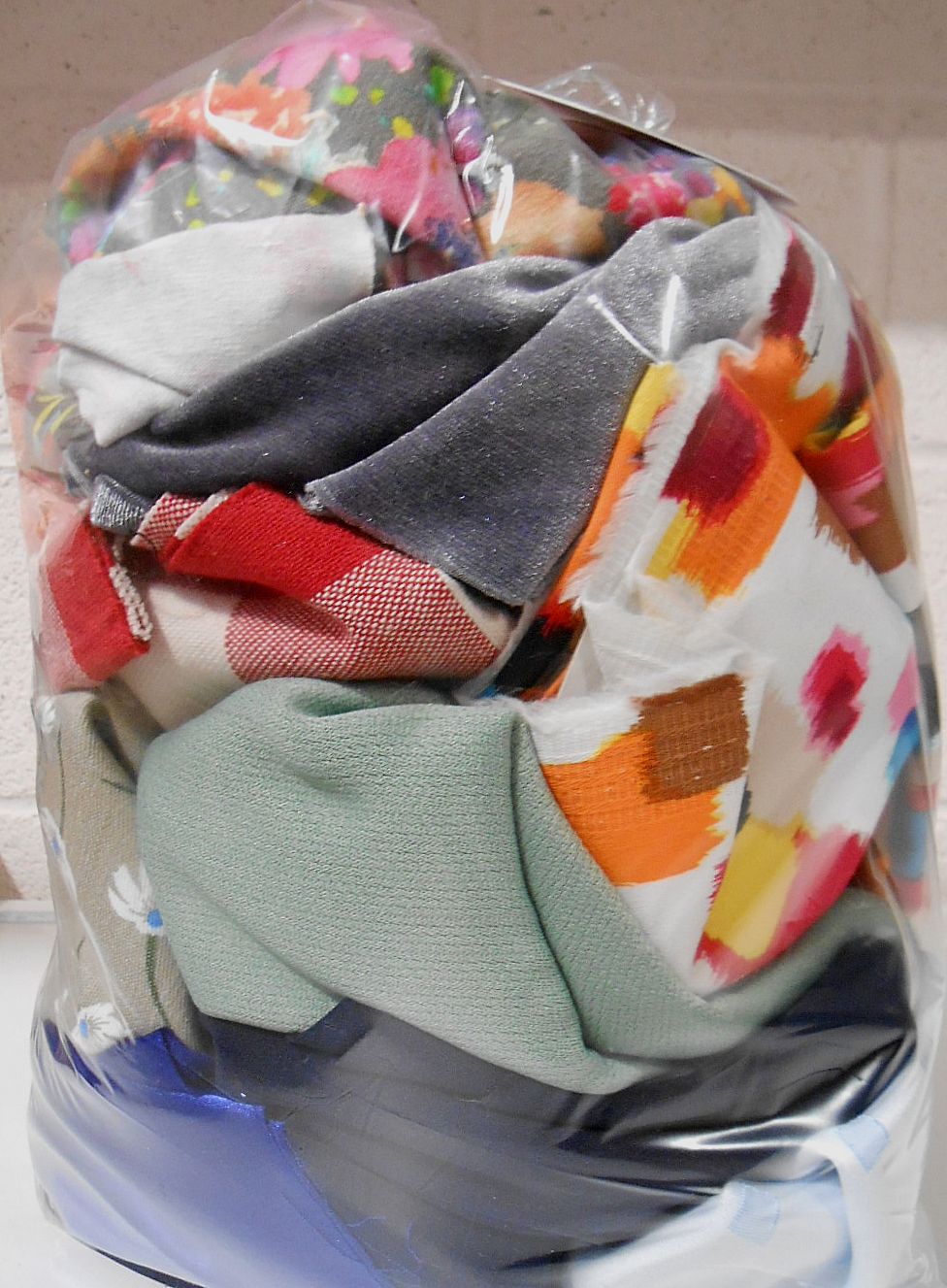 Colourful fabric scraps in a clear plastic bag.