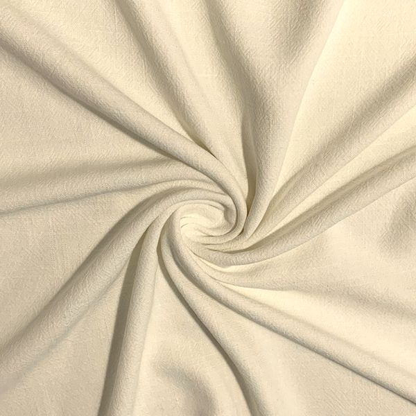 Close-up of swirling cream fabric texture.