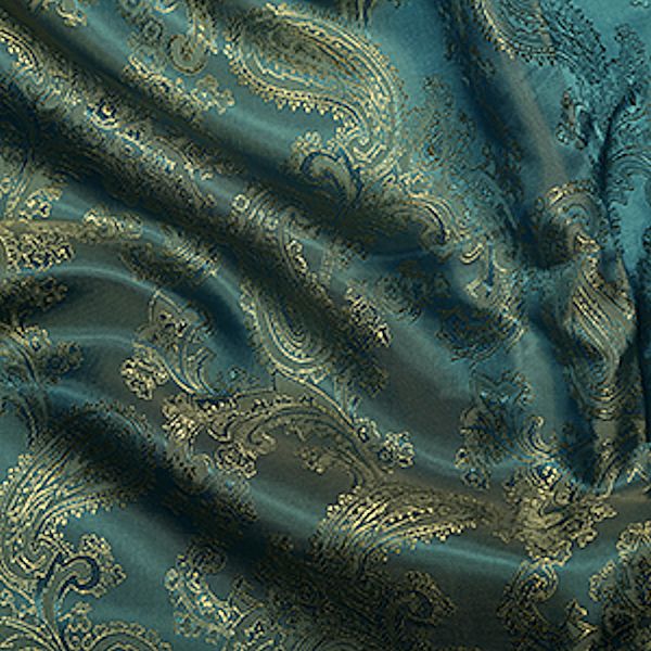Teal paisley patterned fabric texture.