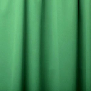 Close-up of green curtain fabric with folds.