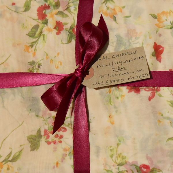 Floral chiffon fabric with pink ribbon and price tag.