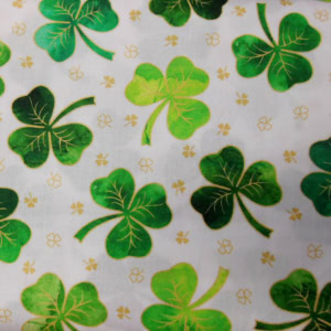 Green clover pattern on white fabric background.