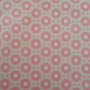 Pink circular pattern on beige fabric background.